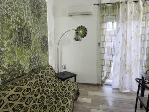 a bedroom with a bed and a lamp and curtains at Appartamento In Centro in Iglesias