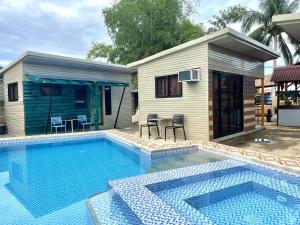 una piscina di fronte a una piccola casa di 13 ways Room Rentals a Panglao