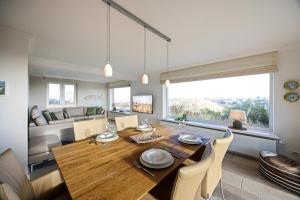 a dining room with a table and a couch at Haus Sonnenland in Hörnum