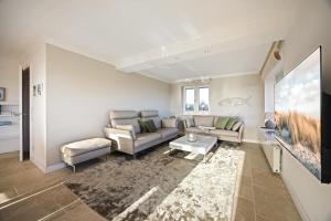 a living room with a couch and a table at Haus Sonnenland in Hörnum