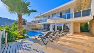 a villa with a swimming pool and lounge chairs at Kalkan 4 Bedroom Villa 6630 in Kalkan