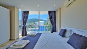 a bedroom with a large bed with a large window at Kalkan 4 Bedroom Villa 6630 in Kalkan +52 photos