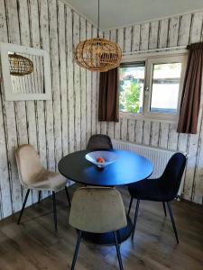a dining room with a blue table and chairs at Veluwe Happy Together in Epe