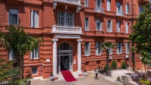 a large red brick building with a white doorway at Hotel Imperial - Liburnia in Opatija