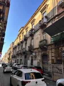 un gruppo di auto parcheggiate in una strada con edifici di Jacupeddu's house a Catania