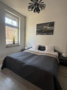 a bedroom with a large bed and a chandelier at I'M Apartment SILVER I centrum free parking in Bolesławiec
