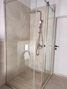 a shower with a glass door in a bathroom at Barn Ville in Almaty