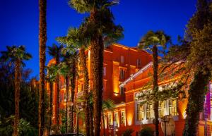 a building with palm trees in front of it at Hotel Imperial - Liburnia in Opatija