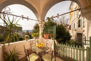 - un balcon avec une table et une corbeille de fruits dans l'établissement Villa Artur heritage - Luxury apartment, à Rijeka