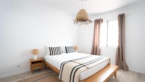 a white bedroom with a bed and a window at Amaro Oasis by LovelyStay in Funchal
