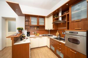 une cuisine avec des armoires en bois et des comptoirs blancs dans l'établissement Villa Artur heritage - Luxury apartment, à Rijeka 17 autres photos