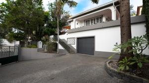 a white house with a garage and a driveway at Amaro Oasis by LovelyStay in Funchal