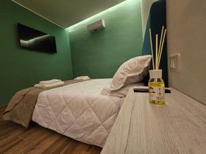 a bedroom with a bed and a table with a bottle at Da Nonno Antonio in Bari