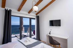 ein Schlafzimmer mit Bett und Schreibtisch und ein Balkon in der Unterkunft Villa Dolce Vita in Ivan Dolac
