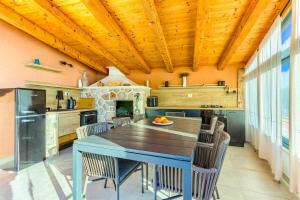 eine Küche mit Tisch und Stühlen und einem Kamin in der Unterkunft Villa Dolce Vita in Ivan Dolac