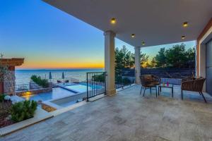 ein Haus mit einer Terrasse mit Blick auf das Meer in der Unterkunft Villa Dolce Vita in Ivan Dolac