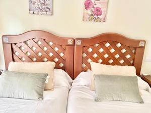 een bed met een houten hoofdeinde en twee kussens bij Apartamento Cimadevilla 22 in Gijón +31 foto's