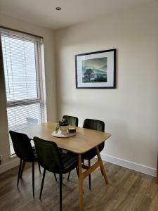 a dining room with a wooden table and chairs at 7 Thadan Apartments in Addlestone