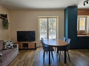 a living room with a table and a couch at Apartament Astra - Bliżej Zdroju in Polanica-Zdrój