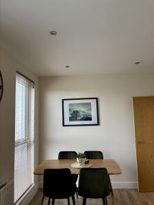 a dining room table with chairs and a picture on the wall at 7 Thadan Apartments in Addlestone +10 photos