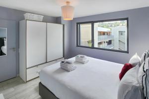 a bedroom with a large white bed and a window at Confluence in Lyon