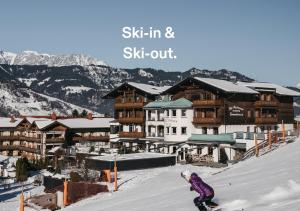 eine Person, die ein Snowboard auf einem schneebedeckten Hang reitet in der Unterkunft Sonnhof Alpendorf - an adults only place in St. Johann im Pongau