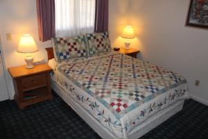 a bedroom with a large bed with two lamps on tables at Barewood Inn & Suites in Wofford Heights