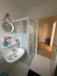 a white bathroom with a sink and a shower at Apartmenthaus Iris&Jasmin in Friedrichshagen