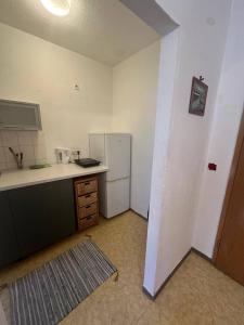 a kitchen with a white refrigerator and a counter at Apartmenthaus Iris&Jasmin in Friedrichshagen