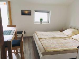 une chambre avec deux lits et un bureau et une fenêtre dans l'établissement Meedehof Moorhausen, WH Ziegenstall, à Varel