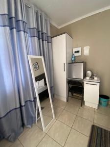 a room with a desk and a curtain and a table at Mosas Home in Serowe