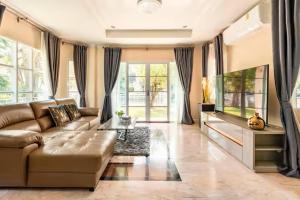 a living room with a couch and a flat screen tv at Top family house in peaceful area with lake view 3BR 15 mins to city in Chiang Mai