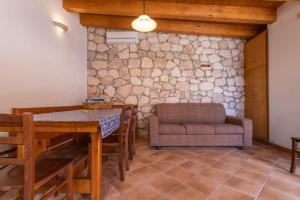 a dining room with a table and a couch at Dammuso Ignazio in Lampedusa