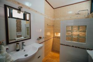 Un baño con lavabo y ducha con espejo. en Ban Thong U, The Landmark, en Chiang Mai