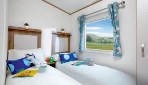 two twin beds in a room with a window at WH - Smugglers Cove 02 in Aberaeron