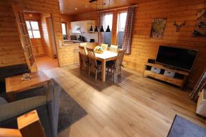 a living room with a table and a television at Feriendorf Blauvogel Blauvogel 001 in Hasselfelde