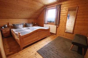 a bedroom with a bed in a log cabin at Feriendorf Blauvogel Blauvogel 001 in Hasselfelde