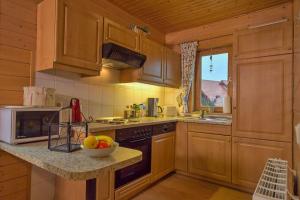 a kitchen with wooden cabinets and a bowl of fruit on a counter at Ferienhaus Blauvogel 4 in Hasselfelde