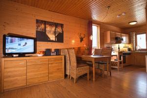 a dining room with a television and a table with chairs at Ferienhaus Blauvogel 4 in Hasselfelde