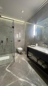 a bathroom with a shower and a toilet and a sink at The Borgo in Ludhiana +14 photos