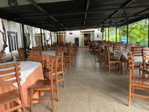 a restaurant with wooden tables and chairs and tables and tablesearcher at Grindlays Regency in Ambepussa