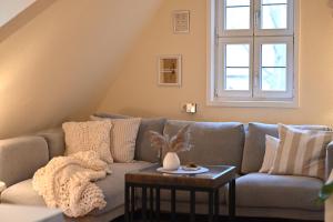 a living room with a couch and a table at TÜRMERSTUBE - Scandi Style - in der historischen Hinterburg Schlitz - nahe Fulda in Schlitz
