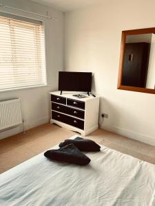 ein Schlafzimmer mit einem Bett mit einer Kommode und einem Spiegel in der Unterkunft East Durham Terraced Home in Easington