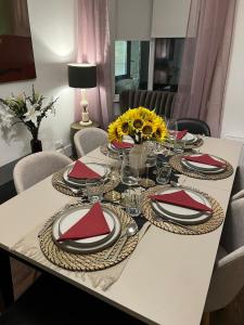 einem weißen Tisch mit roten Servietten und Platten darauf in der Unterkunft East Durham Terraced Home in Easington