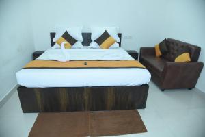 a bedroom with a large bed and a chair at Grand View Hotel in Bengaluru +22 photos