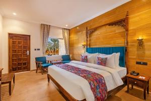 a hotel room with a large bed and a desk at Sterling Rudraksh Jaisalmer in Jaisalmer