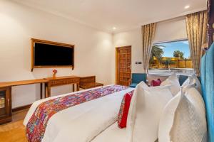 a bedroom with a large bed and a television at Sterling Rudraksh Jaisalmer in Jaisalmer