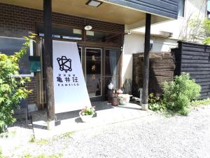 ein Gebäude mit einem Schild davor in der Unterkunft 亀井荘 in Ashikita