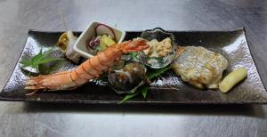 ein Teller mit Meeresfrüchten auf dem Tisch in der Unterkunft 亀井荘 in Ashikita