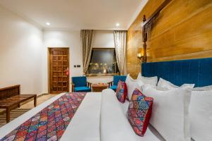 a bedroom with a white bed with a blue headboard at Sterling Rudraksh Jaisalmer in Jaisalmer